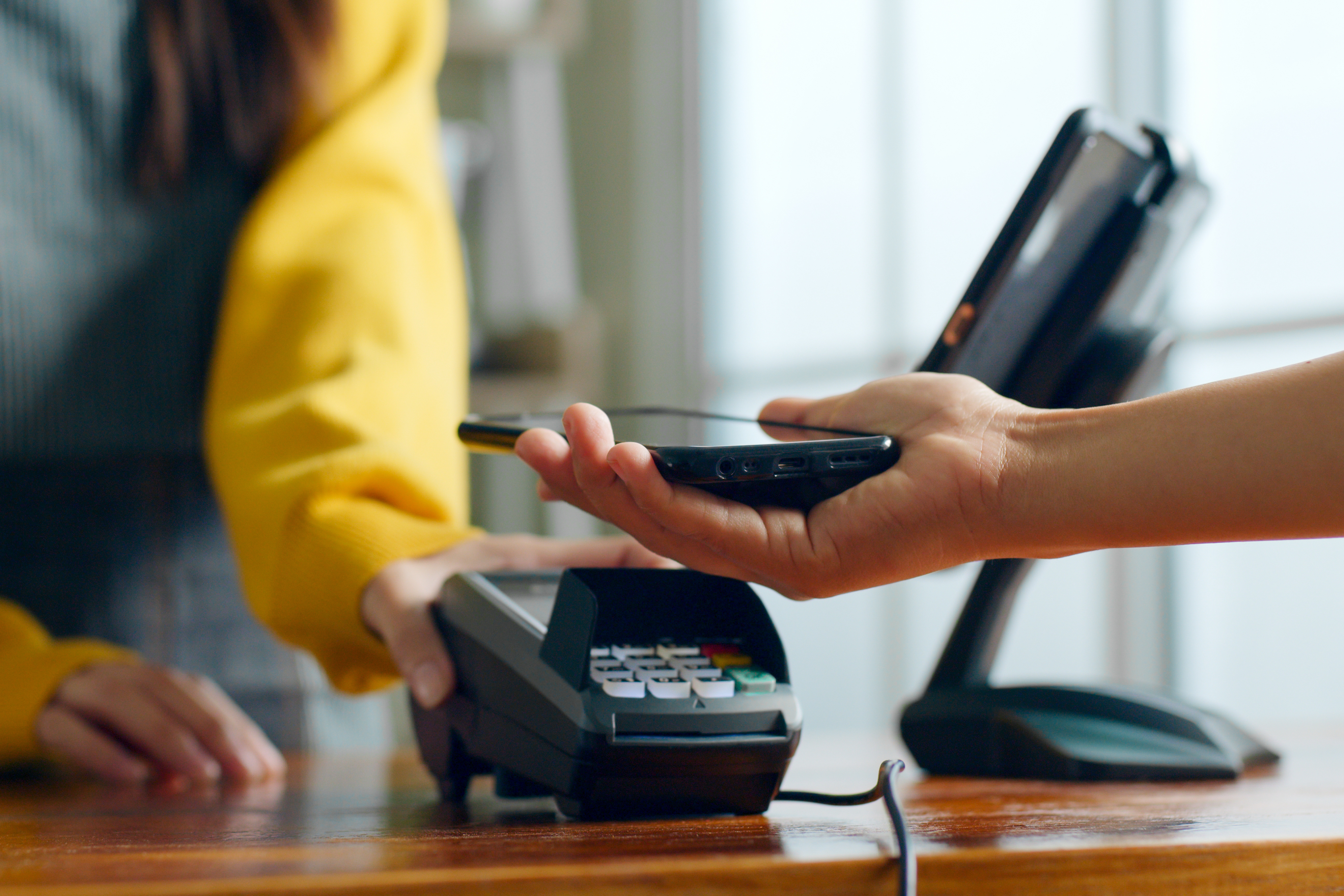 Customer using phone for payment at cafe